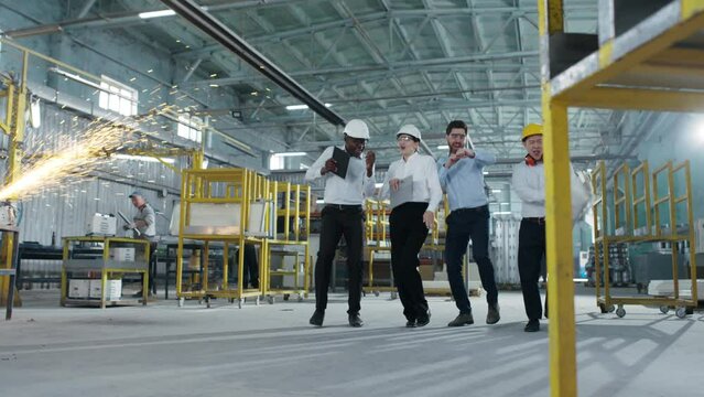 Colleagues have fun at factory. Specialists relieve stress in production. the importance of multiculturalism for improving quality of construction projects.