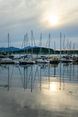 Obraz premium Boats reflection in the harbor of Oban at sunset, in Argyll, Scotland, UK
