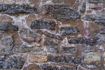 imagen detalle textura pared de piedras de distintos tamaños, formas y colores, con las juntas de cemento y tierra 