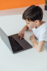 education online online games classes boy sitting at a laptop at school
