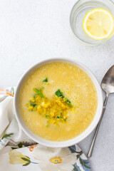 Healthy lunches, cream soup of yellow and orange lentils with fried onions and spinach leaves and curry, useful legums, top view