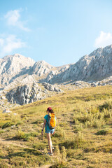 Fototapeta na wymiar a traveler with a backpack walks along a mountain path. a girl walks in the mountains.