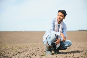 Naklejka na ściany i meble Young indian farmer at agriculture field.