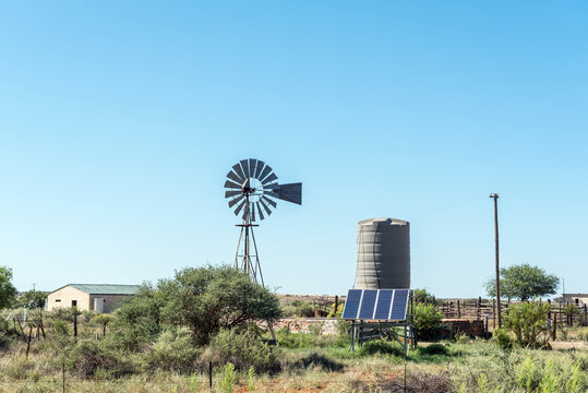Windmill and solar panel driven water pump and water tank