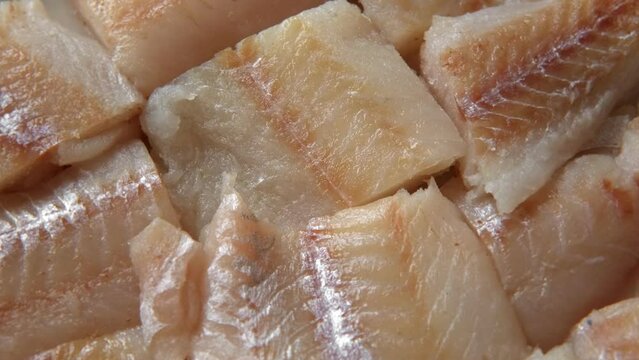 Raw fish fillet is spinning. Top view. Slices of fresh whitefish. Full frame. Sashimi rotation. Close up. Marine market. Video for sale. Cod, pollock loin steaks. Pangasius, tilapia pieces background.