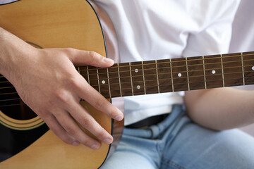 A man plays the guitar. Men's hands play acoustic guitar.  