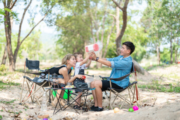 Family enjoying a camping holiday in the countryside ,Camping, travel, tourism, hiking and people. Concept - Happy family with backpacks and thermos at camp.