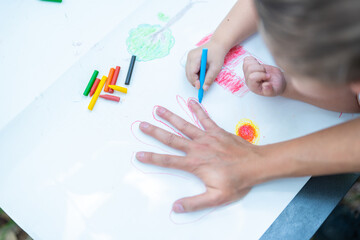 Family activity drawing son using crayons to draw father's hand