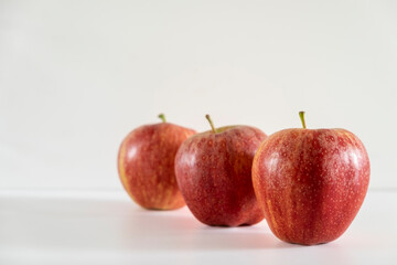 Three fresh red apples on a white background.