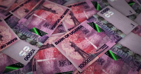Uganda shilling growing pile of money. UGX banknotes loop rotaring. Seamless and looped background concept of finance, economy crisis, inflation and business.