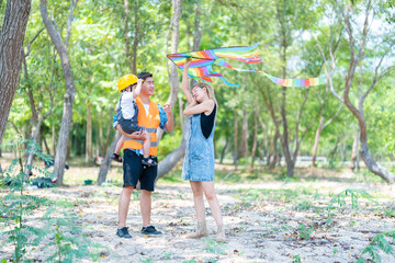 family happy in nature in summer parents and son fly a kite
