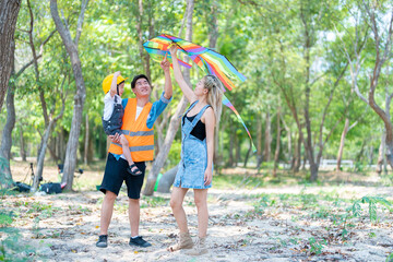 family happy in nature in summer parents and son fly a kite