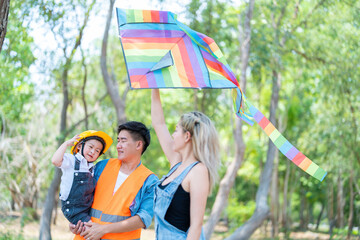 family happy in nature in summer parents and son fly a kite