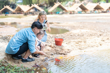 Family activity to scoop fish in a natural stream in the countryside.