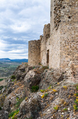 Fototapeta na wymiar imagen de la pared de piedra de un castillo encima de una montaña de piedra con el cielo nublado 