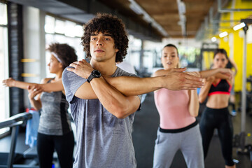 Fototapeta na wymiar Group of fit people working out in a gym. Multiracial friends exercising together in fitness club. Generative AI