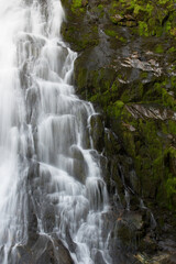 Fototapeta na wymiar lunga esposizione acqua di una cascata delle dolomiti, una splendida cascata con del bel muschio verde di fianco, la bellezza dei panorami delle dolomiti.