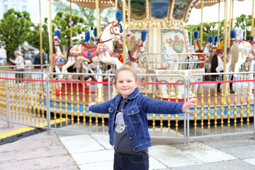 Little happy girl near the carousel near the Grand Hotel in Sopot. Poland