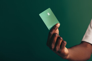 Grabbing electronic banking by the hand: Man holding up a credit card in a studio
