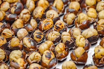 Chestnuts nuts fried on metal baking sheet, selective focus