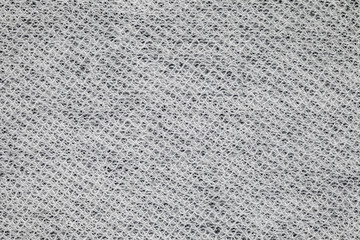 Fabric is white close-up wavy stitches with threads, uniform texture background