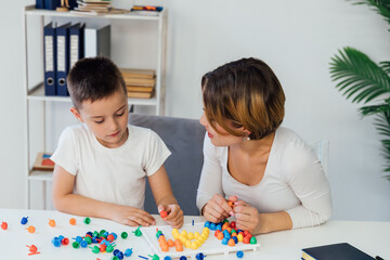 Obraz na płótnie Canvas for children a child psychologist is engaged with a boy in the office of educational games