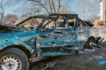 Obraz na płótnie Canvas A civilian car is damaged by fragments of artillery shells. Side view
