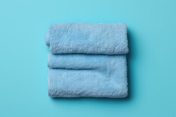 neatly folded blue towel on a plain blue background. Generative AI Generative AI