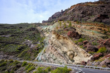 Fuente de los Azulejos de Veneguera, volcanic rocks stratified and colored by the effect of hydromagmatic eruptions. Emerald green, red, yellow rock formation.