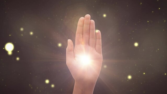 Visualization Of Male Or Female Hand Reaching Out To Show Hamsa Religious Gesture on Magical Dark Background. Bright Light Appearing In The Middle Of Palm. Traditional Protection Sign Concept.