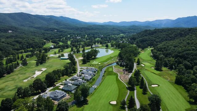 Aerial rotating parallax shot over The Greenbrier golf courses with mountains in the background during summer.