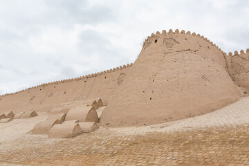 Walls of ancient Kunya Ark (Kohna Ark) fortress at cloudy day. Khiva (Xiva), Uzbekistan