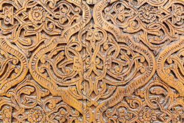 Carved wooden door decoration. Floral design pattern. Close up fragment. Khiva (Xiva), Uzbekistan