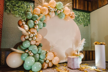 Arch decorated green, brown, golden balloons, dry autumn leaves for wedding ceremony. Celebration...