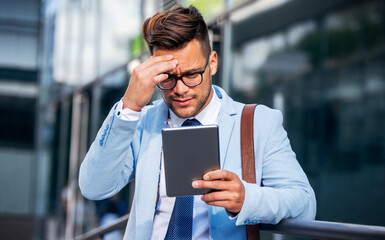 Bad news about project. Frustrated businessman talking via tablet with his client about project....