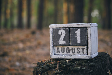 August 21 summer month, wooden calendar with date and month in forest.