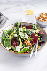 Healthy Salad made from Green Salad Leaves, Rocket Salad, Slices of Beetroot, Avocado, pieces of Feta Cheese, Walnuts and Sesame Seeds.