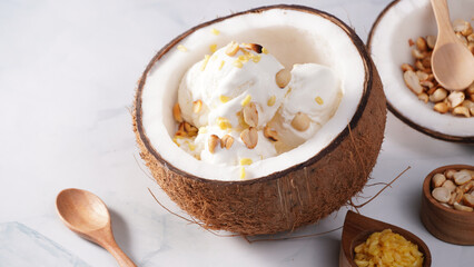 Coconut ice cream topped with roasted peanuts in a coconut shell macro shot. (spot focus)
