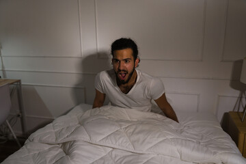 Afraid man waking up from a scary nightmare