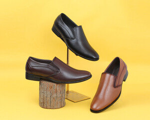 brown black and tan leather moccasins theme shot on yellow background