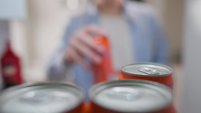Products, Man Slowly Opens the refrigerator, extends his hand Inside the apartment. Camera in motion Adult male Grabbing a can of drinks In a cooling container, eating
