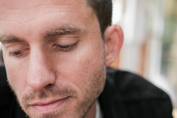 A close up portrait of a sad man looking down