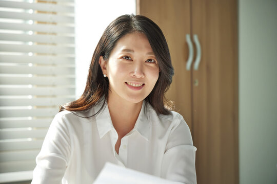 흰색 셔츠를 입고 미소짓는 여성 리더 