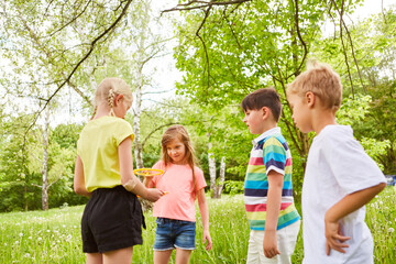Children playing with bubble wand in garden