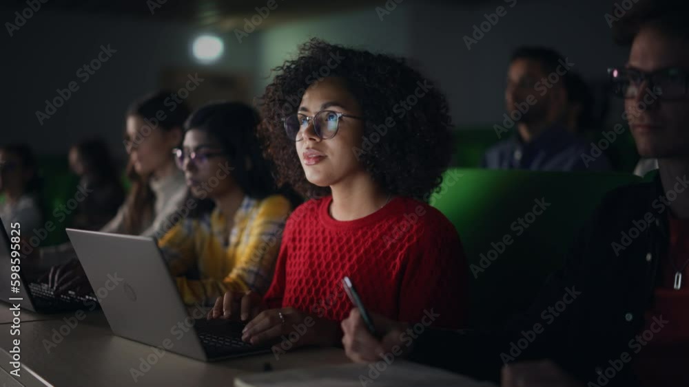 Aufkleber Beautiful Multiethnic African Female Student Studying in University with Diverse Classmates. Young Black Woman Using a Laptop Computer. Applying Her Knowledge to Acquire Academic Skills in Class