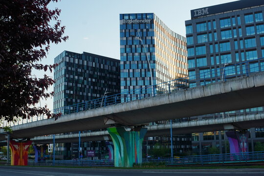 Orhideea Towers blue glass office buildings housing headquarters of Bitdefender, IBM and Finastra corporations and overpass bridge with colorful pillars in Bucharest, Romania on May 1, 2023