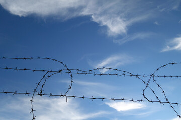 Barbed wire fence and blue sky.