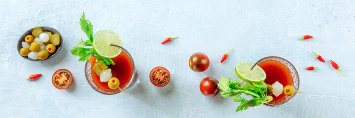 Bloody Mary cocktail with garnish panorama, overhead flat lay shot. Two glasses of spicy tomato...