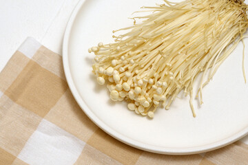 Popular in asian cuisine fresh needle mushroom or enoki close up, enokitake Flammulina velutipes.