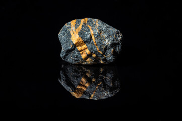 ozdobny kamień z pomarańczowymi paskami na czarnym tle